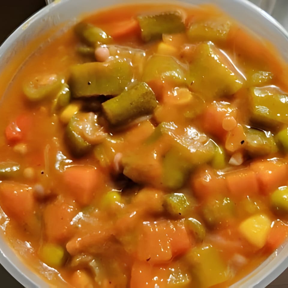 Close-up of Gail's Soul Food okra and tomatoes, a vibrant stew with carrots and corn.