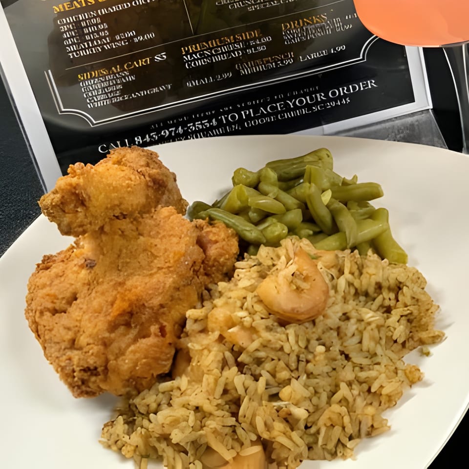 Gail's Soul Food fried chicken, rice with shrimp, and green beans on a white plate.